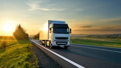 businessman overseeing three parked lorries