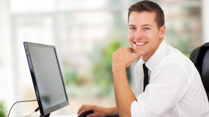 Homem a trabalhar no computador e a sorrir
